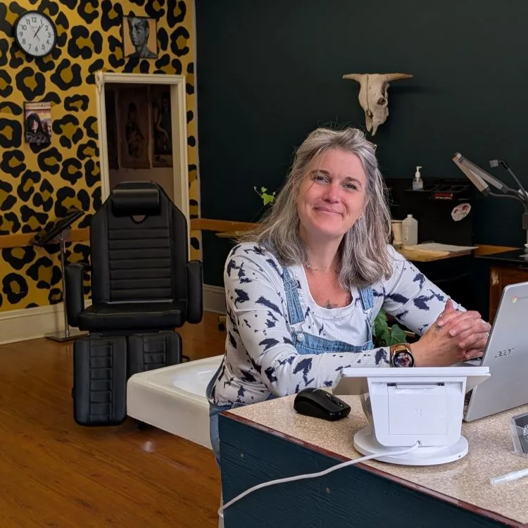 The studio: leopard-print wall, tattoo chair and front desk